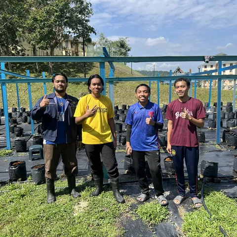 Four student caretakers standing together in front of the fertigation frame