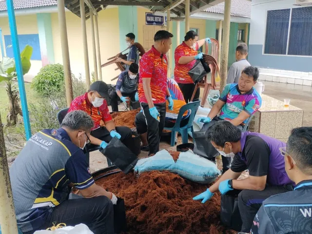 Volunteers and visiting educators bagging growing medium together under a school corridor