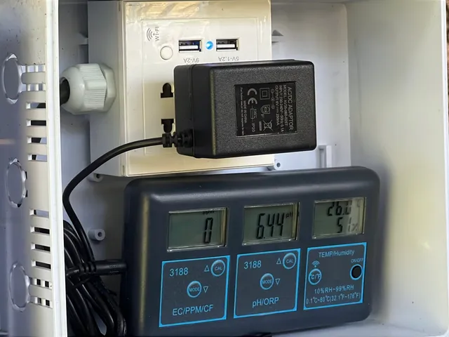 Close-up of the JFI control box showing live EC, pH, and temperature/humidity readings